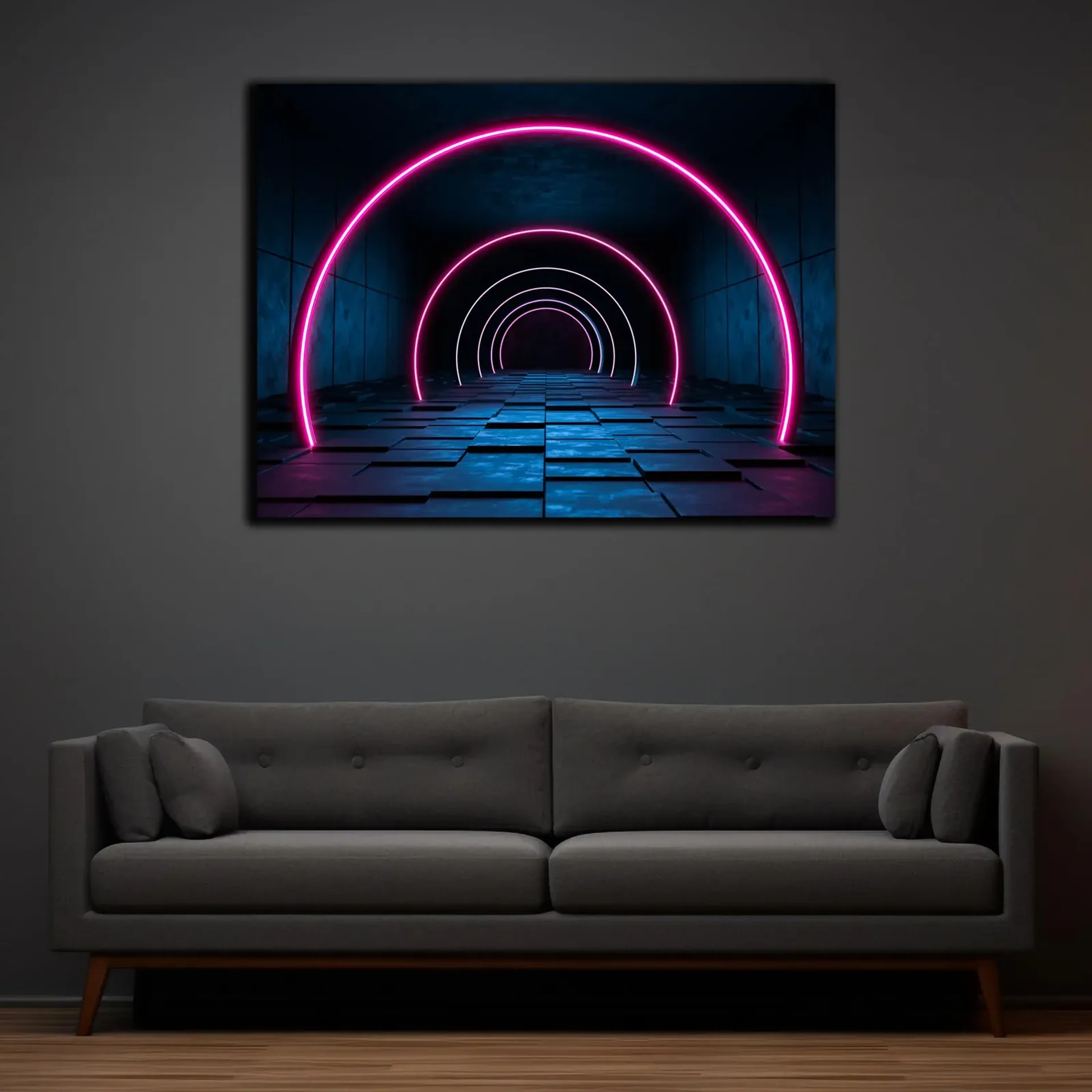 Über einem grauen Sofa hängt ein Motiv mit pinken Lichtbögen in einem dunklen, blau beleuchteten Tunnel.