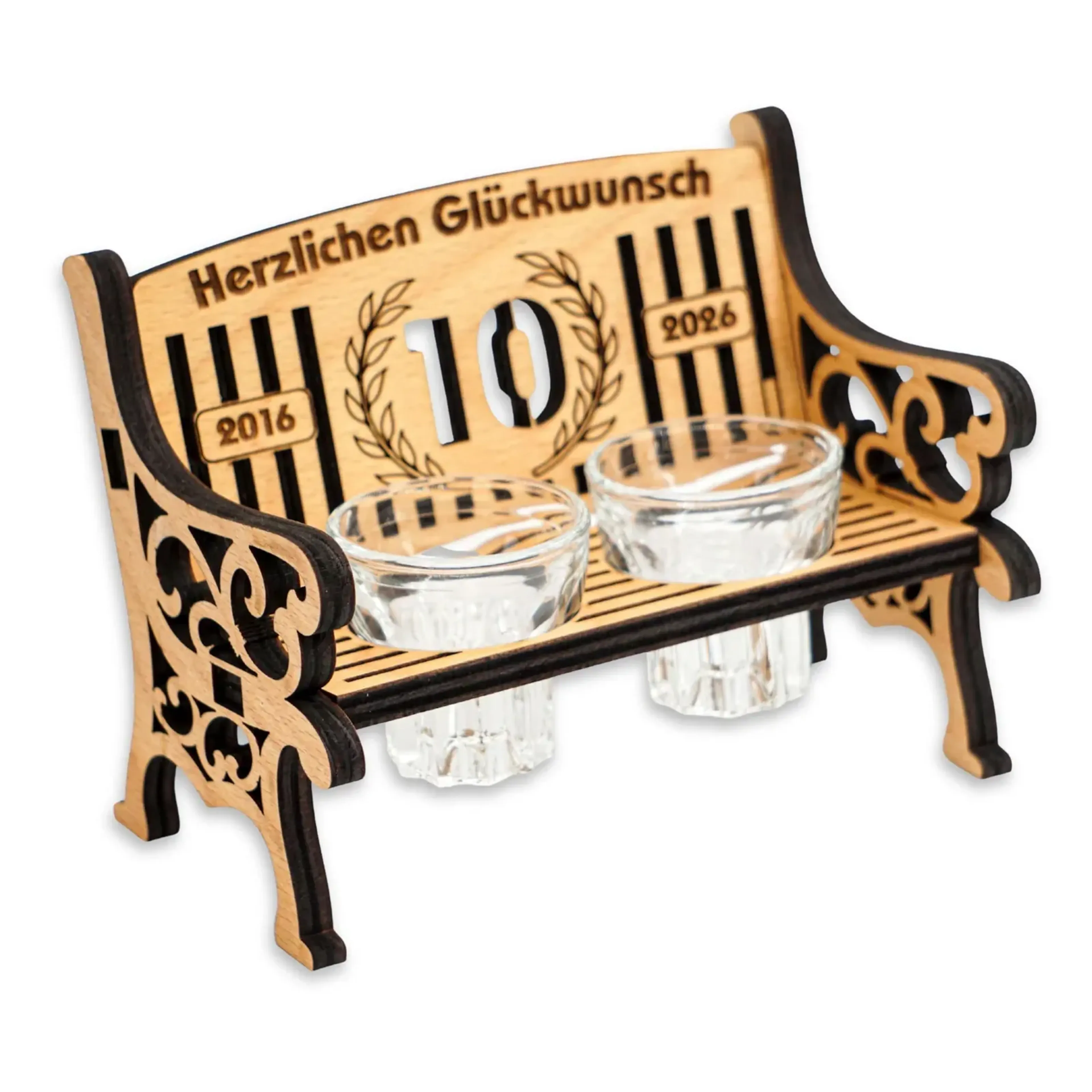 Verzierte Holzbank mit zwei Schnapsgläsern und einer beispielhaften Jubiläumsgravur mit der Zahl zehn.