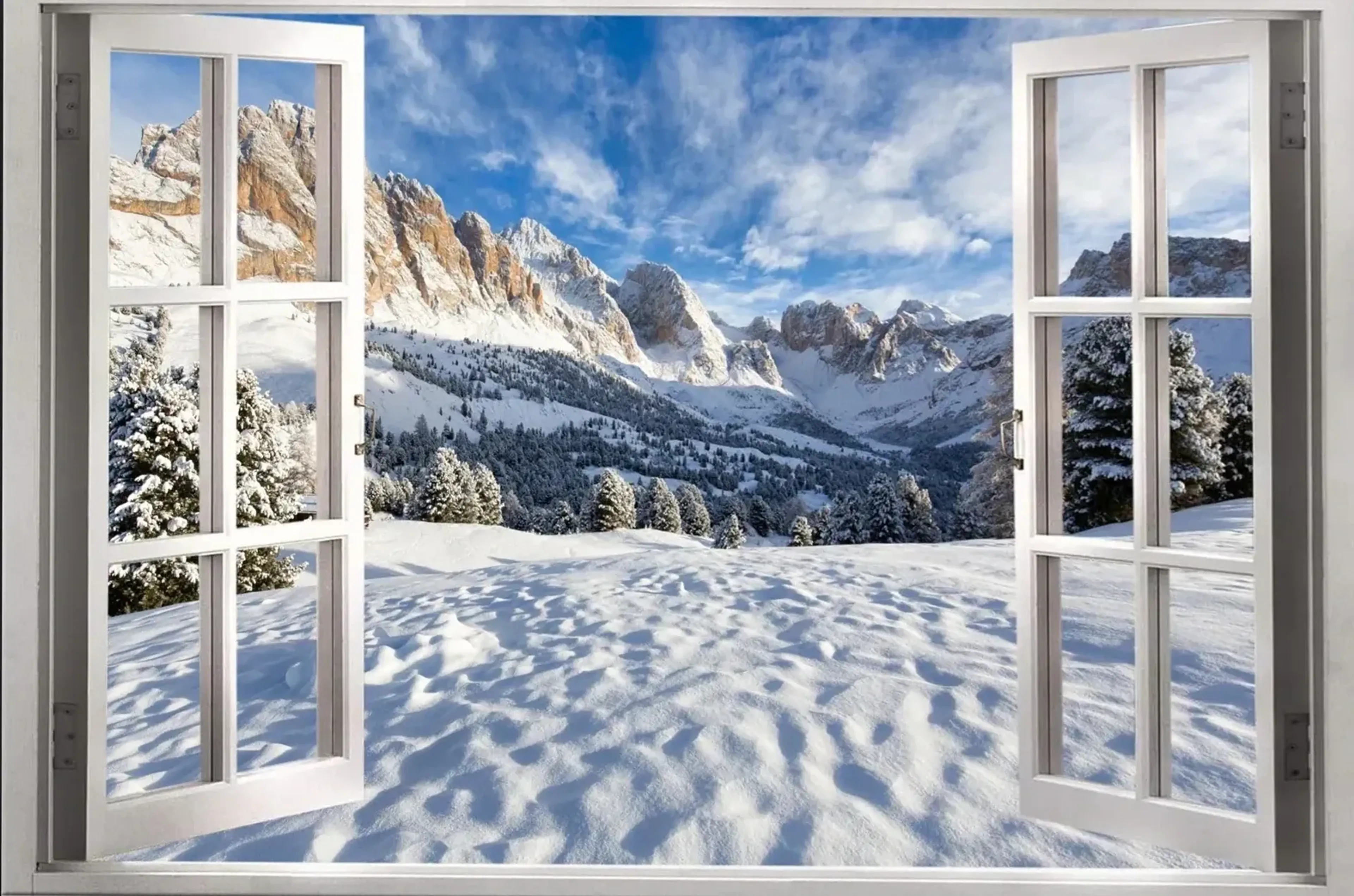 Geöffnete weiße Fensterflügel rahmen verschneite Wiesen, Nadelbäume und felsige Berge unter blauem Himmel.