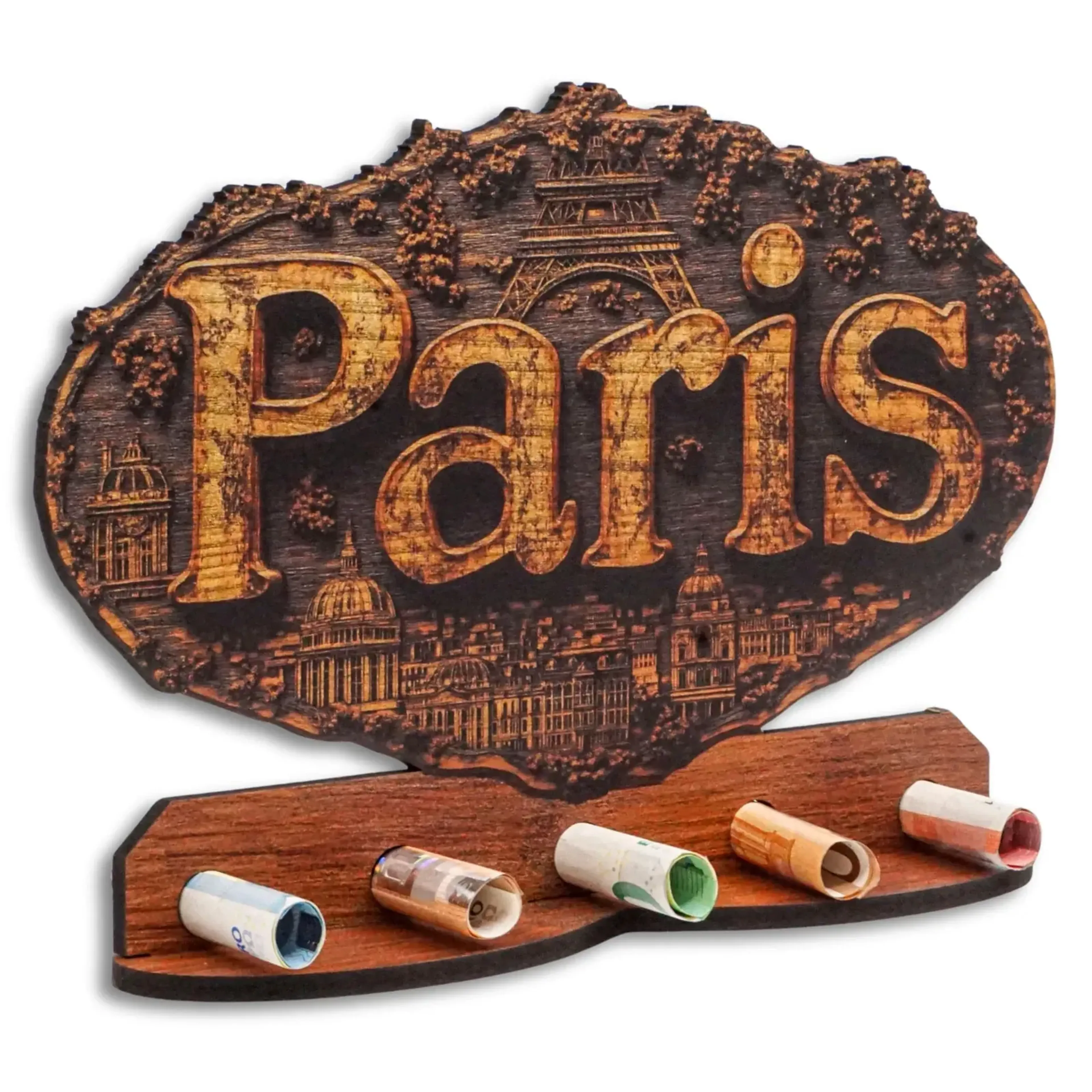 Paris-Schriftzug mit Eiffelturm und Gebäuden in dunkler Holzoptik über einer Ablage mit gerollten Geldscheinen.