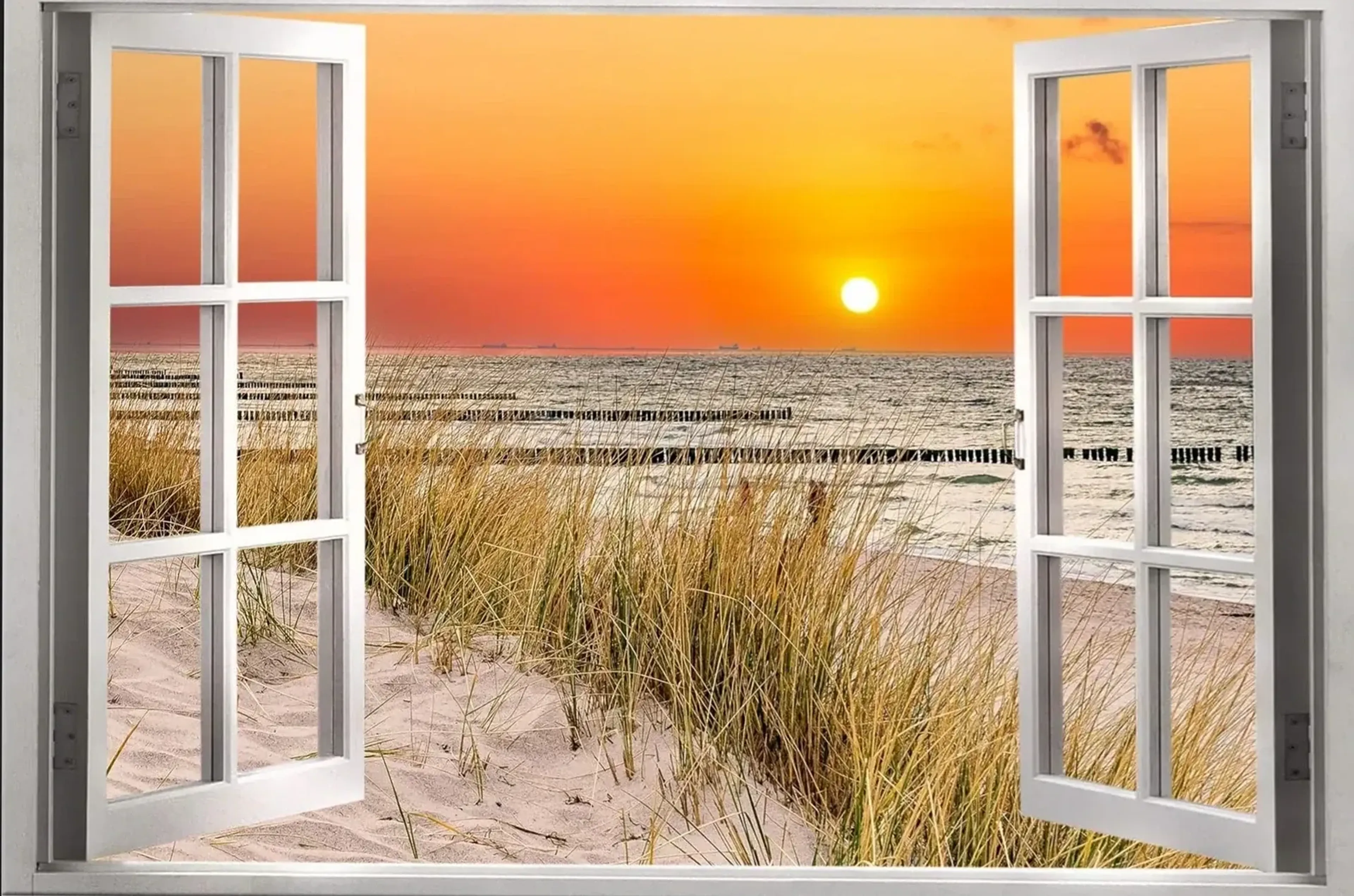 Geöffnete weiße Fensterflügel vor Strandgras, Sand und Meer mit Pfahlreihen unter einer orangefarbenen Abendsonne.