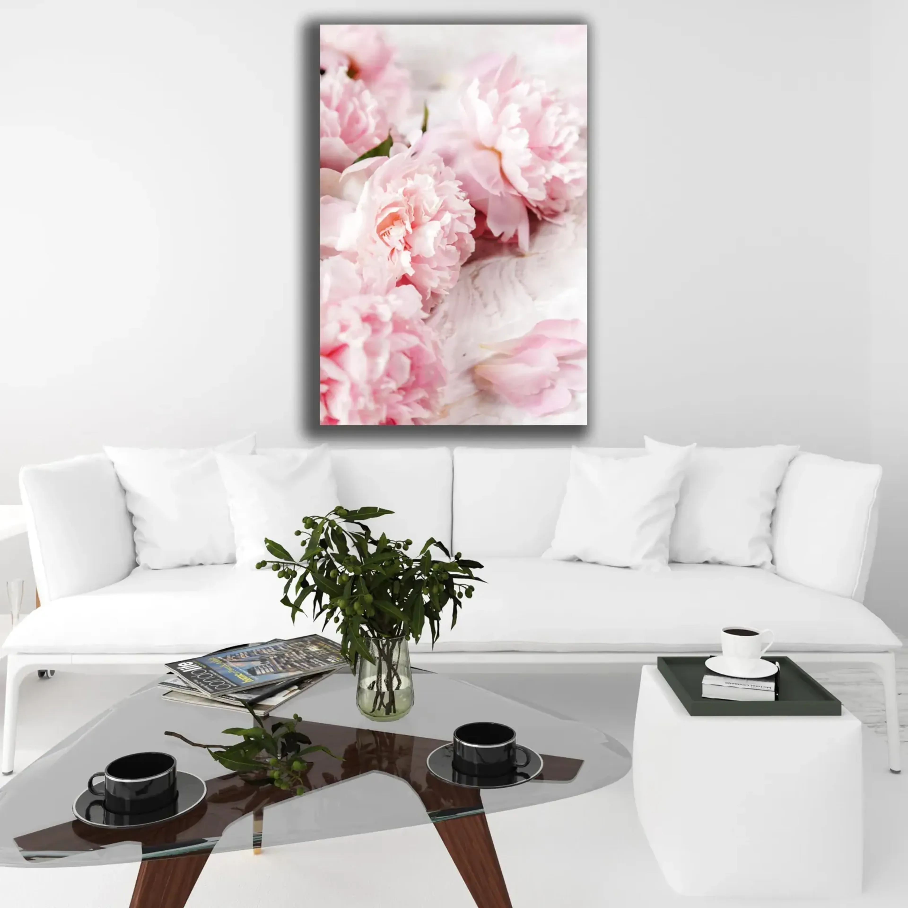 Über einem weißen Sofa hängt ein hochformatiges Motiv mit dicht gefüllten rosa Blüten auf hellem Grund.
