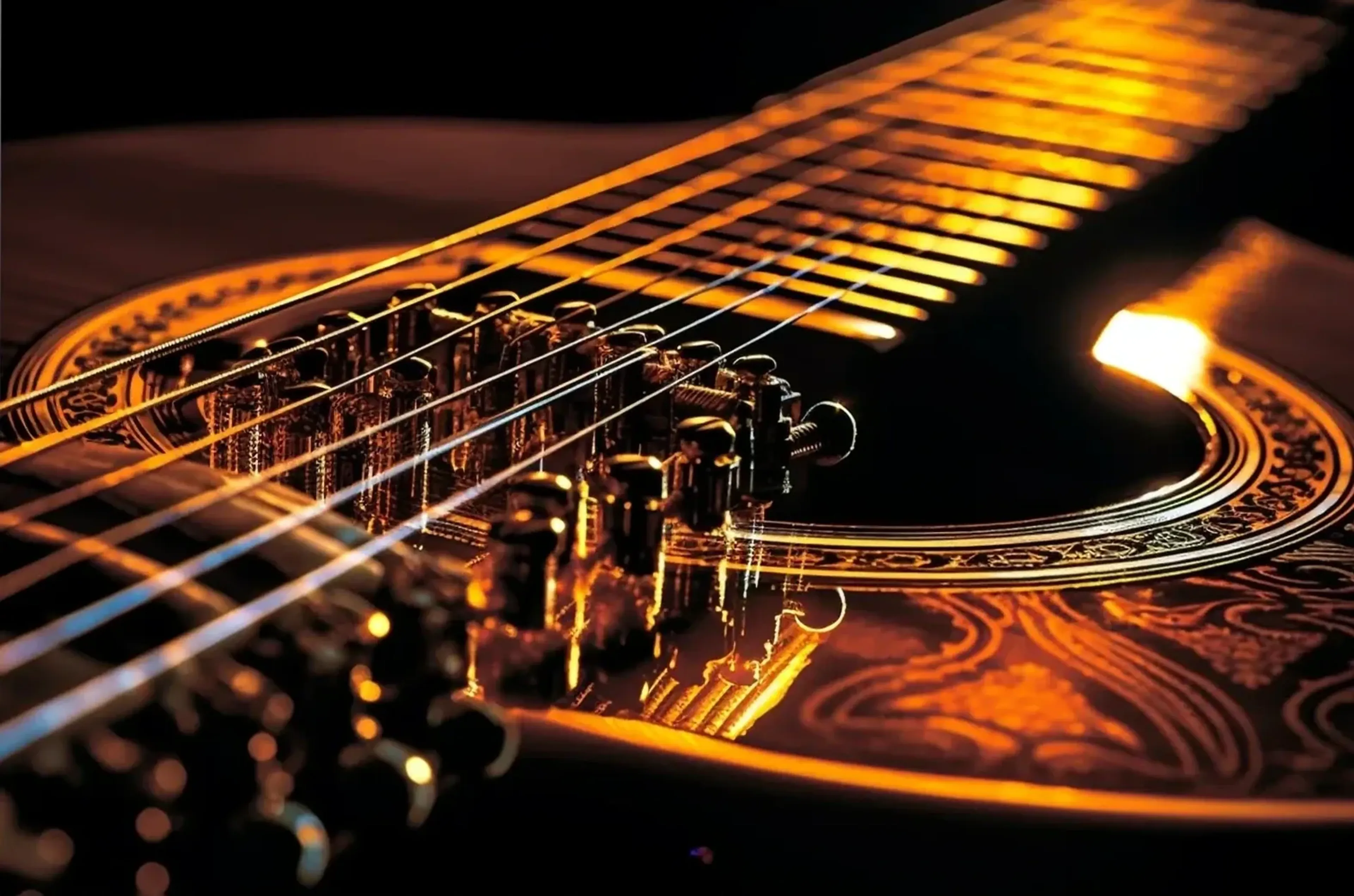 Nahaufnahme einer verzierten Gitarre mit diagonalen Saiten und goldgelben Lichtreflexen.